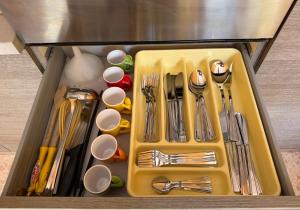 a yellow tray with silver utensils in a drawer at Casa Tètta two styles living together in Sant'Agnello