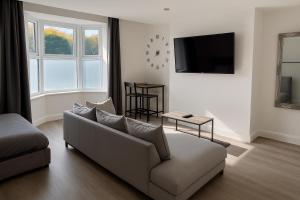 a living room with a couch and a tv at LT 1 - Studio Apartment - Free Street Parking in Leicester