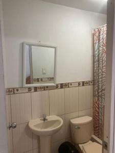 a bathroom with a sink and a toilet and a mirror at Starfish in Paracas