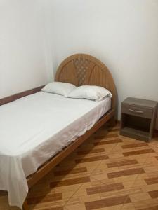 a bed with a wooden headboard and a night stand at Starfish in Paracas