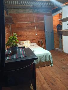 a bedroom with a bed and a table with a potted plant at Vista Surf Pipa Hostel in Pipa