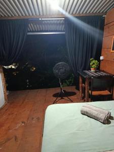a bedroom with a bed and a fan in a room at Vista Surf Pipa Hostel in Pipa