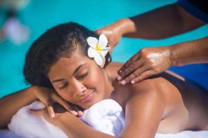 a woman with a flower on her head getting a massage at Taumeasina Island Resort in Apia