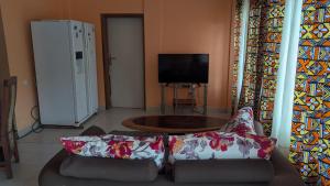 a living room with a couch and a television at Villa le chant des Alizés 