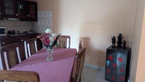 a dining room table with a vase of flowers on it at Villa le chant des Alizés 