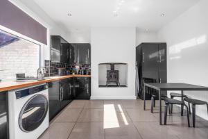 a kitchen with a washing machine and a table at Three Bedroom House by Brookland Stays Serviced Accommodation Short Lets Manchester with Free WiFi in Manchester