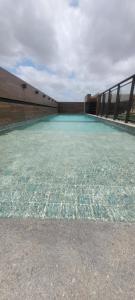 a large pool of blue water in a building at STUDIO Mar azul 1206 in São Luís