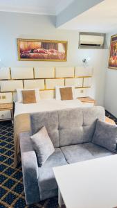 a hotel room with a couch and a bed at Bəy Hotel Baku in Baku +1 photo
