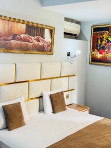 a bedroom with a white bed and a painting on the wall at Bəy Hotel Baku in Baku