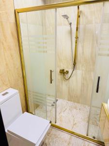 a shower with a glass door and a toilet in a bathroom at Bəy Hotel Baku in Baku