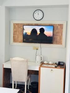 a tv on a wall above a desk with a table sidx sidx sidx at Bəy Hotel Baku in Baku