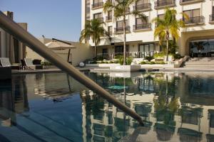 una piscina con palmeras y un edificio en HS HOTSSON Hotel Leon, en León