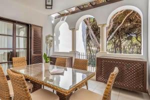 a dining room with a glass table and chairs at Pine Cliffs Village in Albufeira