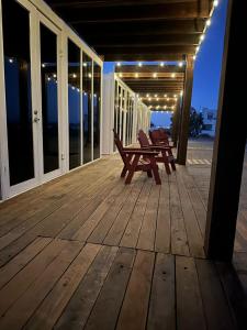 a deck with two benches and lights on a house at Wine Hotel Punta Arena in Bahía de los Ángeles