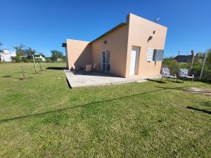 a small house with two chairs in a yard at Chacra MARIANA in Gualeguay