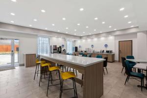 a lobby with a bar with chairs and tables at Sonesta Essential La Porte in La Porte