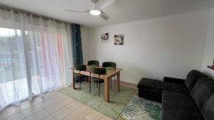 a living room with a table and chairs and a couch at Songe Péi - T2 - Est Réunion - Piscine & Parking in Saint-André +11 photos