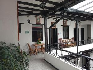 a porch of a house with a table and chairs at Hostal Flores in Quito