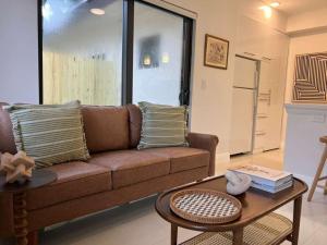 a living room with a brown couch and a table at Chic Modern Studio with Queen Bed in Fort Lauderdale