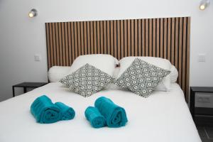 - un lit avec 2 oreillers bleus dans l'établissement Appartement Saintes Juste et Ruffine centre ancien, à Prats-de-Mollo-la-Preste