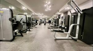 Un gimnasio con filas de máquinas y gente en él. en Brickell 32th Floor AKA by Palermo Home Miami, en Miami