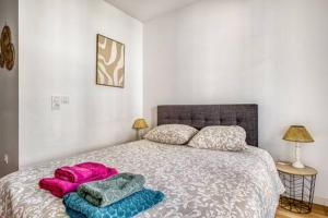 a bedroom with a bed with three pillows on it at charmant appartement en plein coeur de Trouville in Trouville-sur-Mer