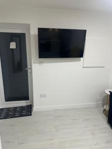 a living room with a flat screen tv on a wall at Cozy Lodge in Rochester