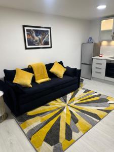 a black couch with yellow pillows in a living room at Cozy Lodge in Rochester