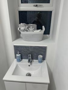 ローチェスターにあるCozy Lodgeのバスルーム(バスケット付きのシンク) +4枚の写真