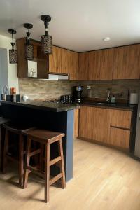 a kitchen with a black counter and wooden cabinets at Hermosa casa en el centro de Filandia, Quindío in Filandia