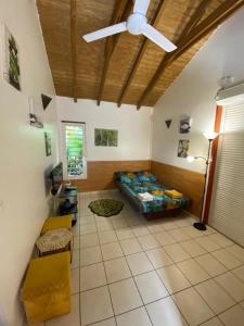 a bedroom with a bed and a ceiling fan at Bungalow Ludivine in Sainte-Anne