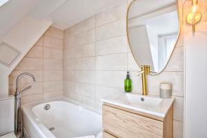 a bathroom with a tub and a sink and a mirror at Le Criquet - Hypercentre - Filet de détente in Caen