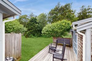 a wooden deck with two chairs on it at Little Cozy Corner in Edgartown