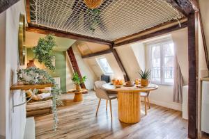 a room with a table and chairs in a room at Le Criquet - Hypercentre - Filet de détente in Caen +14 photos