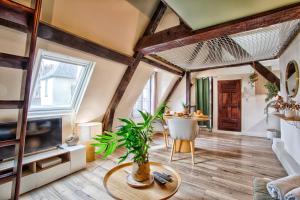 a living room with a table and a tv at Le Criquet - Hypercentre - Filet de détente in Caen