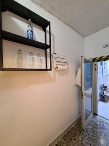 a room with a shelf with glass bottles on the wall at Salento - Casa Vacanza di appartamento open space in Nardò +123 photos