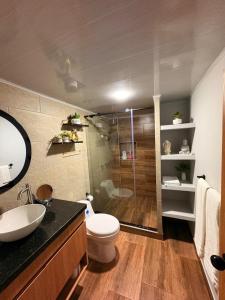 a bathroom with a shower and a toilet and a sink at Hermosa casa en el centro de Filandia, Quindío in Filandia