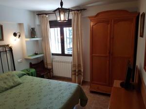 a bedroom with a bed and a cabinet and a window at La Vista de Gredos in Navarredonda de Gredos