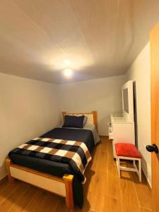 a bedroom with a bed and a chair in it at Hermosa casa en el centro de Filandia, Quindío in Filandia