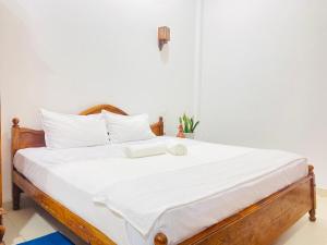 a bed with white sheets and a book on it at Anthony's Villa in Galle