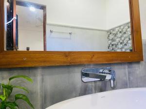 a bathroom with a mirror and a sink at Anthony's Villa in Galle