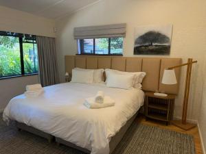 a bedroom with a bed with towels on it at Twice Central Garden Cottage in Stellenbosch