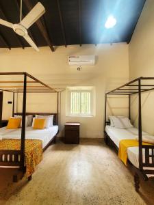 Un dormitorio con dos camas y una ventana en CalmDown, en Ahangama 29 fotos más