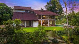 a house with a green yard with stairs leading to it at Clara Villas Amithirigala in Avissawella