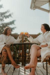 two women in robes sitting at a table with drinks at The Klinck House in Collingwood