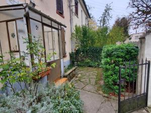 a garden with a gate in front of a house at Le Refuge Nature à 20 min de Paris et d'Orly via RER Juvisy in Draveil