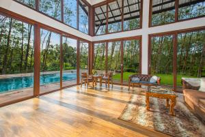 a large living room with a pool and large windows at Clara Villas Amithirigala in Avissawella +18 photos