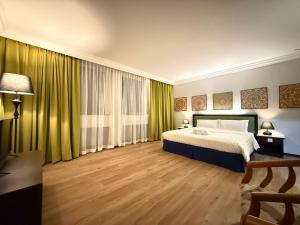 a bedroom with a large bed and green curtains at City Homestay in Miri
