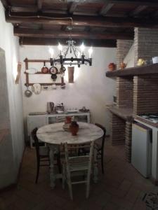a kitchen with a table with chairs and a chandelier at Il Castello della Dama in Bassano in Teverina