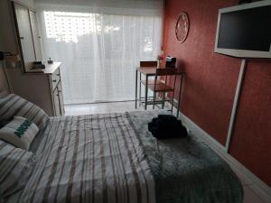 a bedroom with a bed and a television and a desk at Chez Pam et David in Saint-Maixent-lʼÉcole